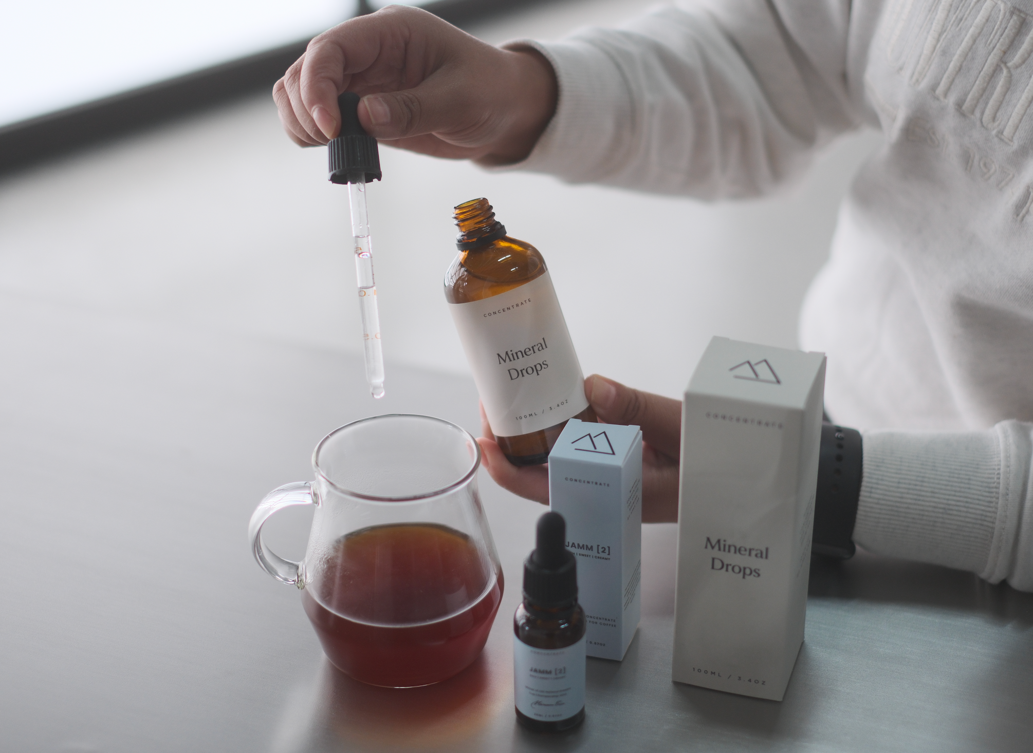 Barista dosing APAX LAB mineral concentrate (co-branded with La Cabra) into filter coffee.