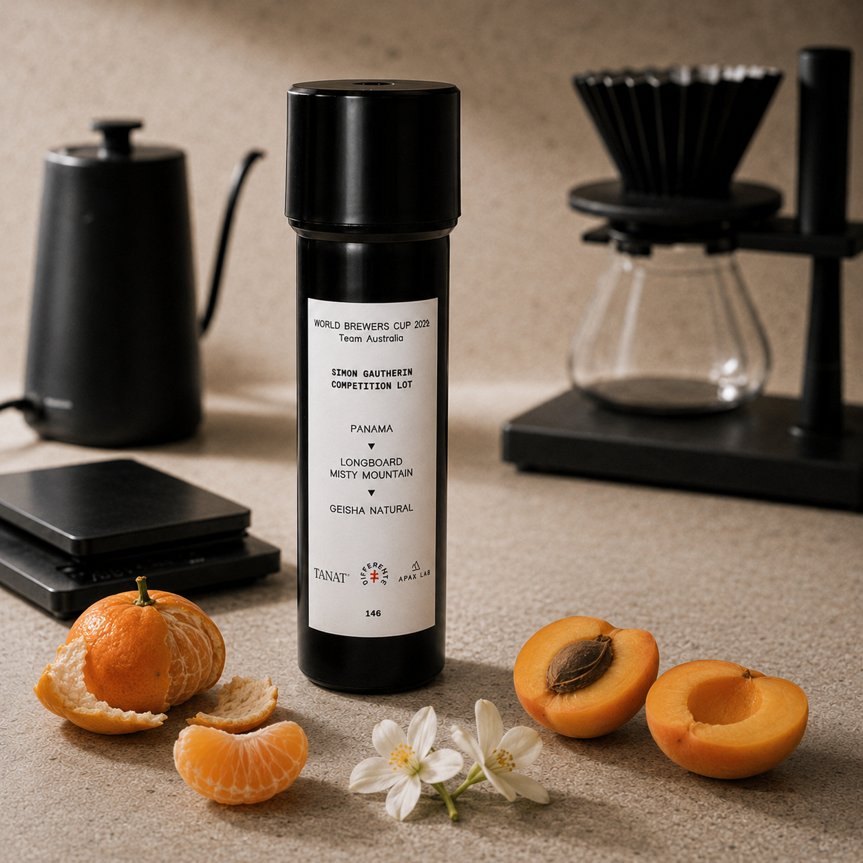 A black cylindrical coffee accessory bottle labeled 'World Brewers Cup 2025' stands on a beige countertop with citrus slices, a white flower, and coffee-making tools in the background.