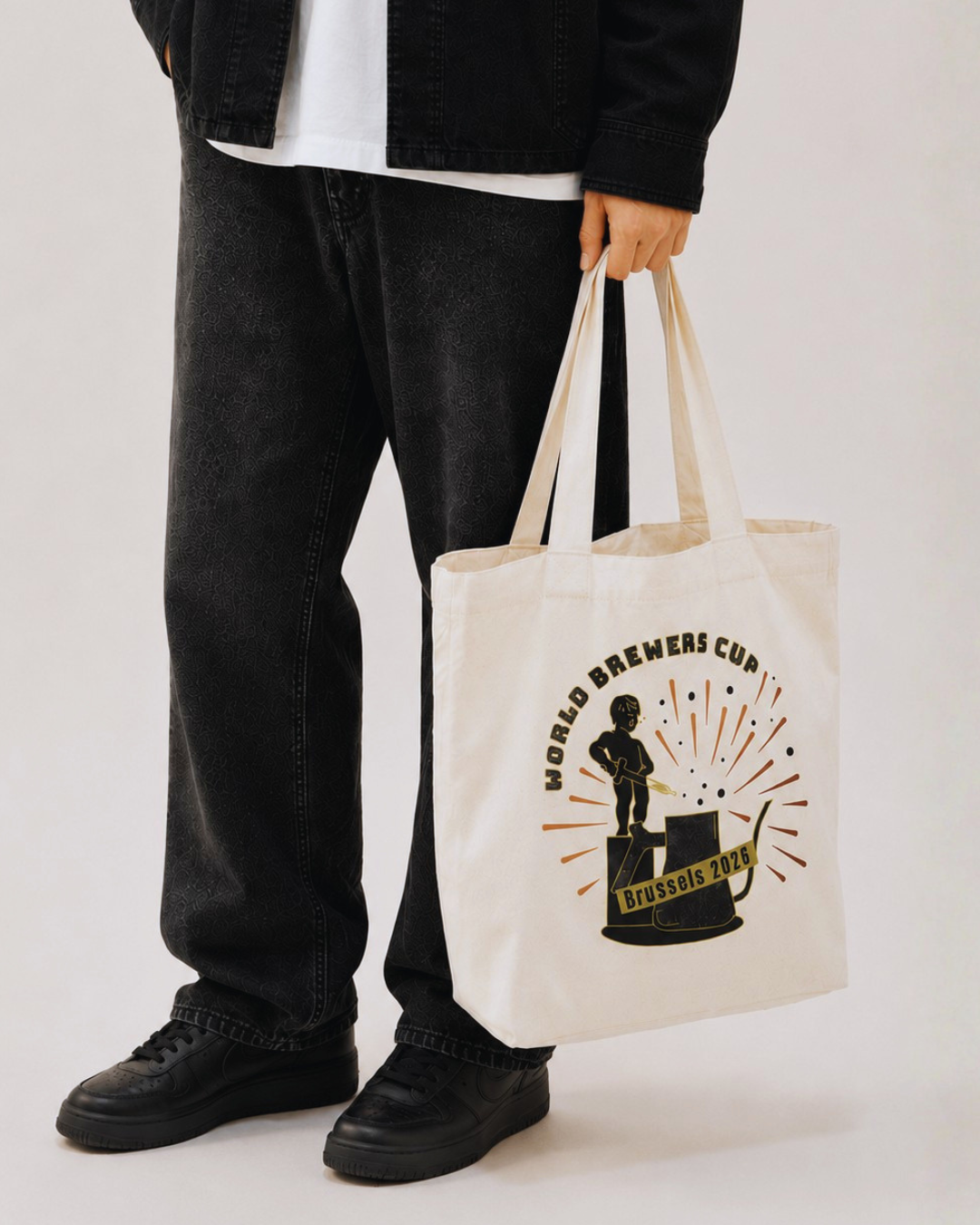 Person holding a tote bag with a logo on a plain background